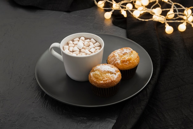 Free photo high angle arrangement with marshmallow drink and muffins