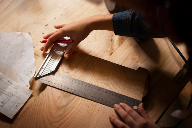 Artigiano ad alto angolo che fa il taglio del legno