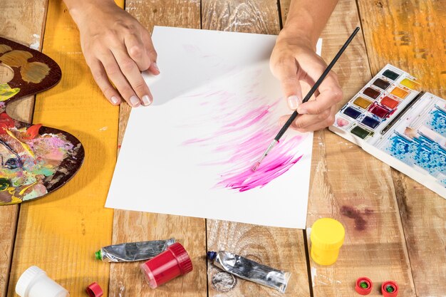 High angle of artist painting on paper