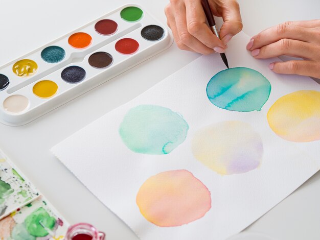 筆と水彩を使ったアーティストの絵画のハイアングル