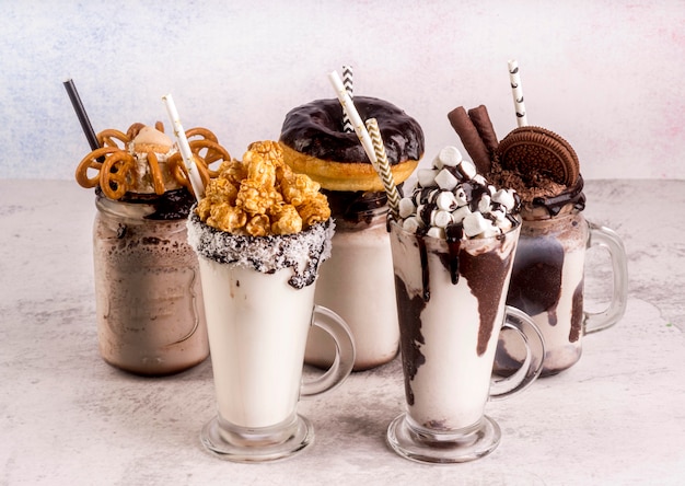 High angle of assortment of desserts with straws and chocolate