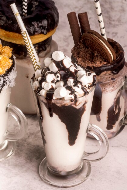 High angle of assortment of desserts with straws