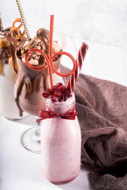 High angle of assortment of desserts with straws