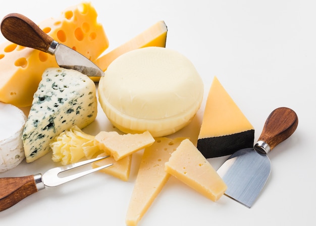 Foto gratuita assortimento ad alto angolo di formaggio gourmet con coltelli da formaggio