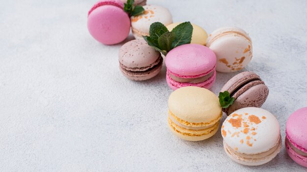 High angle of assortment of macarons with mint and copy space