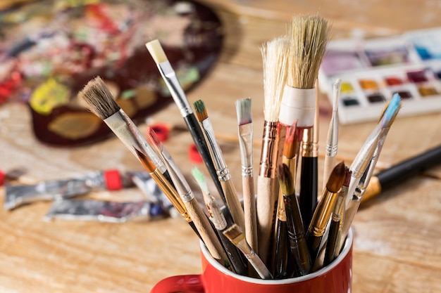 High angle of assortment of paint brushes in mug