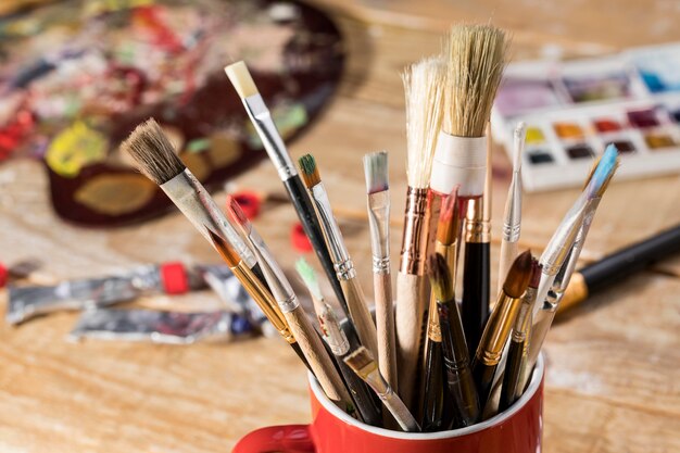 High angle of assortment of paint brushes in mug