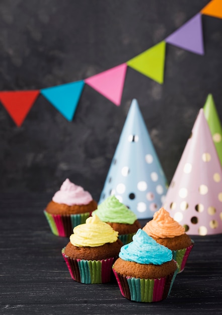 Foto gratuita assortimento ad alto angolo con muffin con glassa colorata