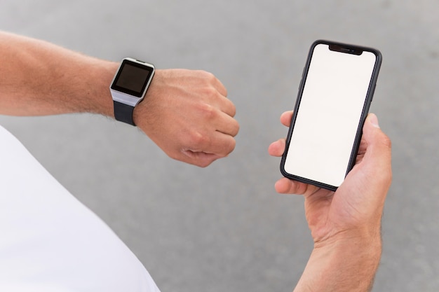 High angle athletic man holding his phone with empty screen