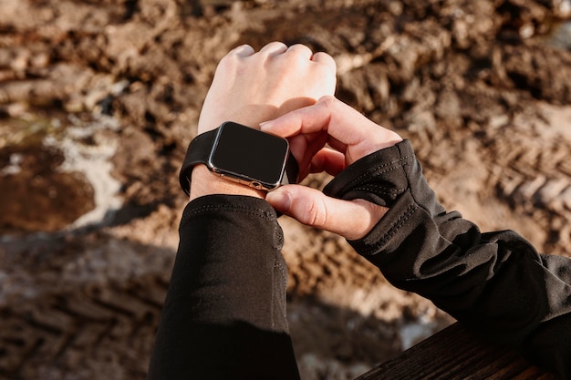 High angle of athletic woman fixing her smartwatch