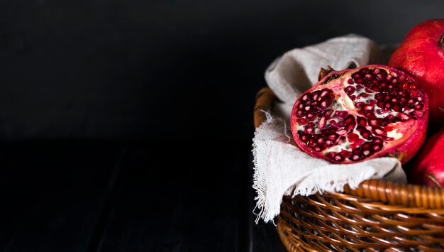 High angle of autumn pomegranates in basket with copy space