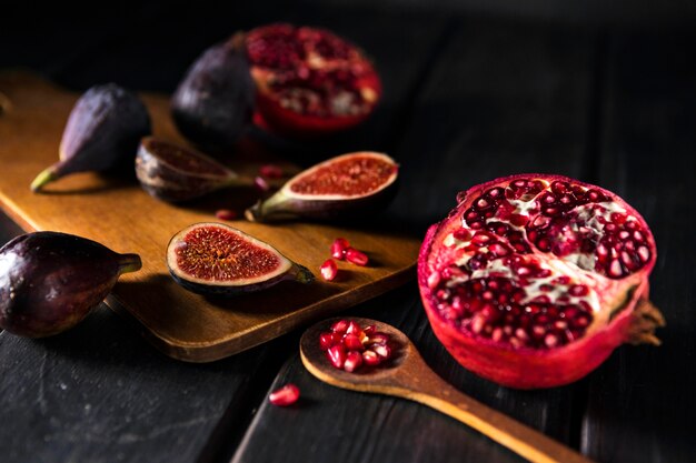 High angle of autumn pomegranates and figs with wooden spoon