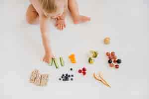 Free photo high angle baby choosing what to eat alone