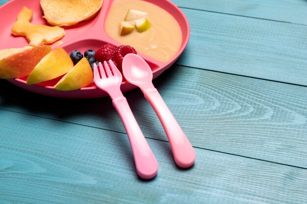 High angle of baby fruit on plate with fruits