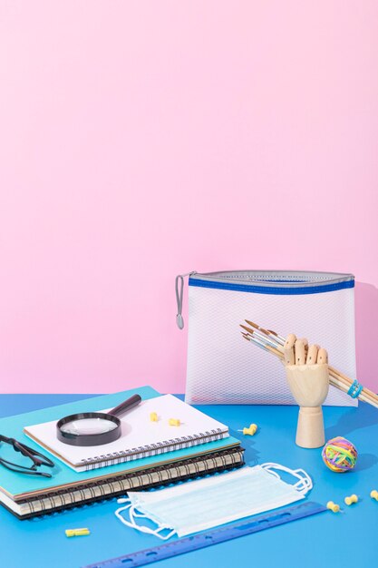 High angle of back to school supplies with notebook and magnifying glass