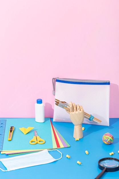 High angle of back to school supplies with scissors and magnifying glass