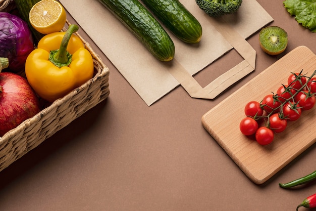 High angle of basket of organic vegetables with grocery bag