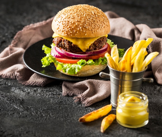 High angle beef burger, fries and sauce with beer