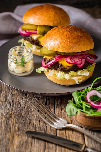 High angle beef burgers with pickles on cutting board