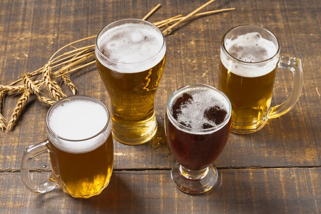 High angle beer in glasses and pint having foam