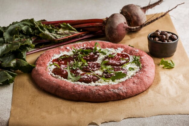 High angle of beet slices on pizza dough with cheese