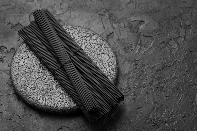 Free photo high angle of black spaghetti bundles on slate