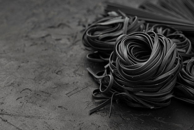 High angle of black tagliatelle on slate