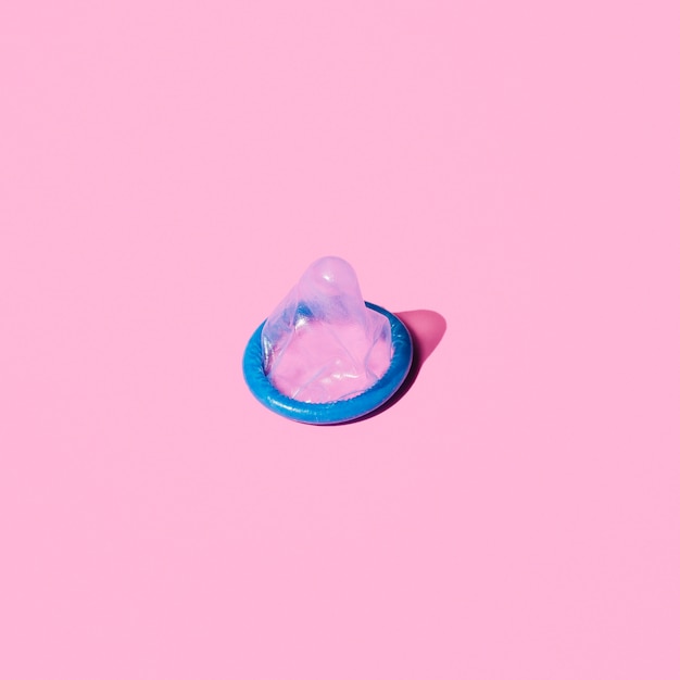 High angle blue condom on pink background