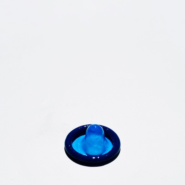 白い背景の上の高角度の青いコンドーム