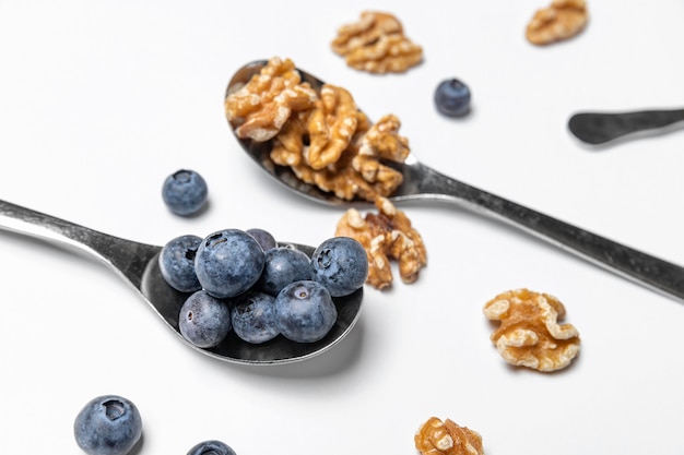 High angle blueberries and walnuts in spoons