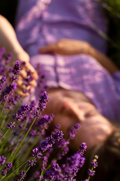 Foto gratuita donna sfocata ad alto angolo che pone sulla lavanda