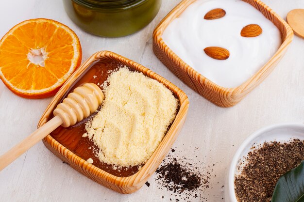 High angle of body butter and orange on wooden table