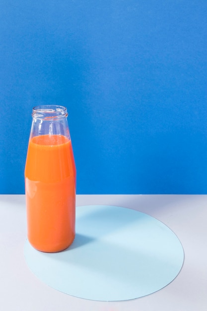 Free photo high angle bottle with orange smoothie