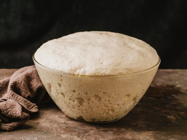 High angle of bowl with growing dough for pizza