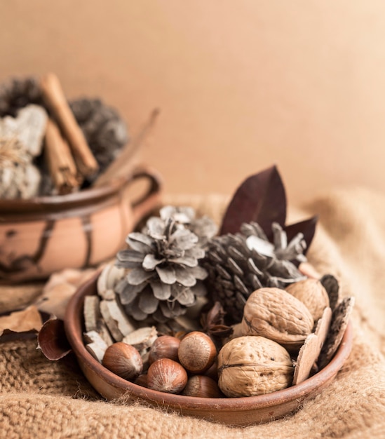 High angle of bowl with pine cones and nuts on burlap