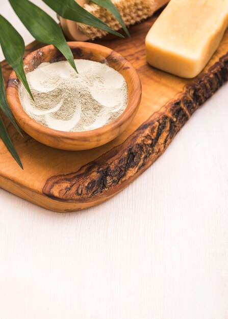 High angle of bowl with powder and leaves with brush