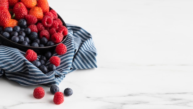 Free photo high angle of bowl with strawberries, raspberries and blueberries