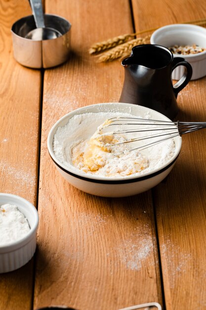 High angle of a bowl with whisk on wooden table