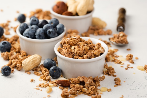 Free photo high angle of bowls with breakfast cereal and blueberries