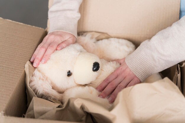 High angle of box with teddy bear being prepared to be shipped