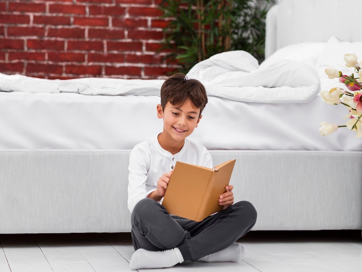 मुफ़्त फोटो high angle boy on floor reading
