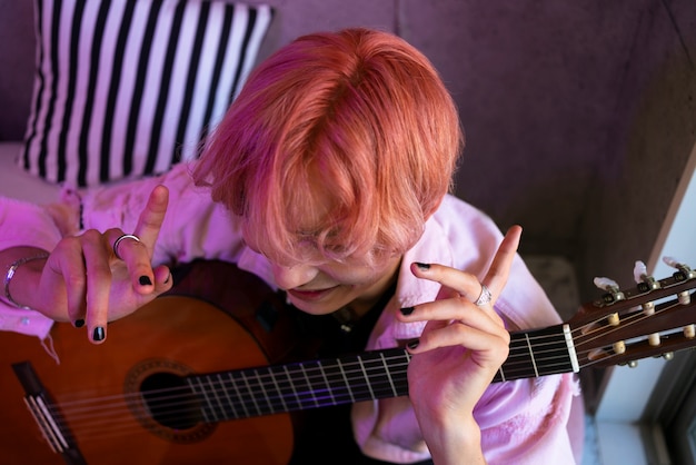 Free photo high angle boy holding guitar