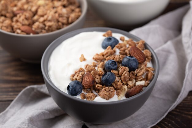 High angle of breakfast cereal in bowl with blueberries and yogurt