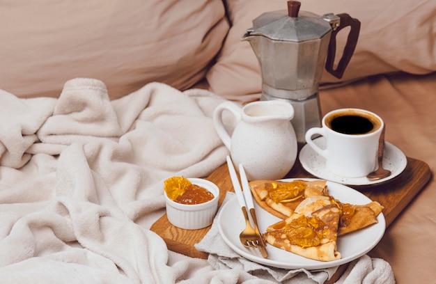 High angle of breakfast crepes with jam and coffee