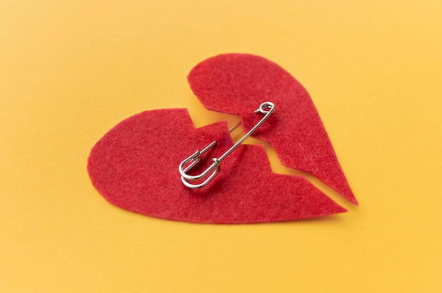 High angle of broken heart put back together with safety pin