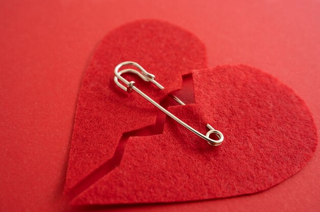 High angle of broken heart put back together with safety pin