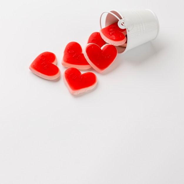 High angle of bucket with heart-shaped sweets and copy space