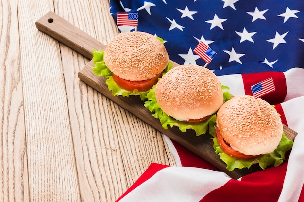 High angle of burgers with american flags on wooden surface