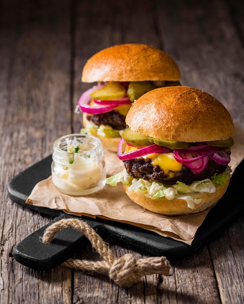 High angle burgers with pickles on cutting board