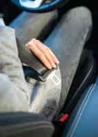 Free photo high angle of businesswoman putting on the seat belt in the car